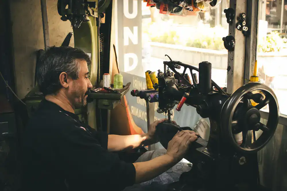 Local artisan hand-stitching a leather shoe